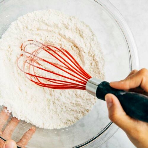 photo of michelle from hummingbird high making homemade cake flour in a glass bowl with a red whisk