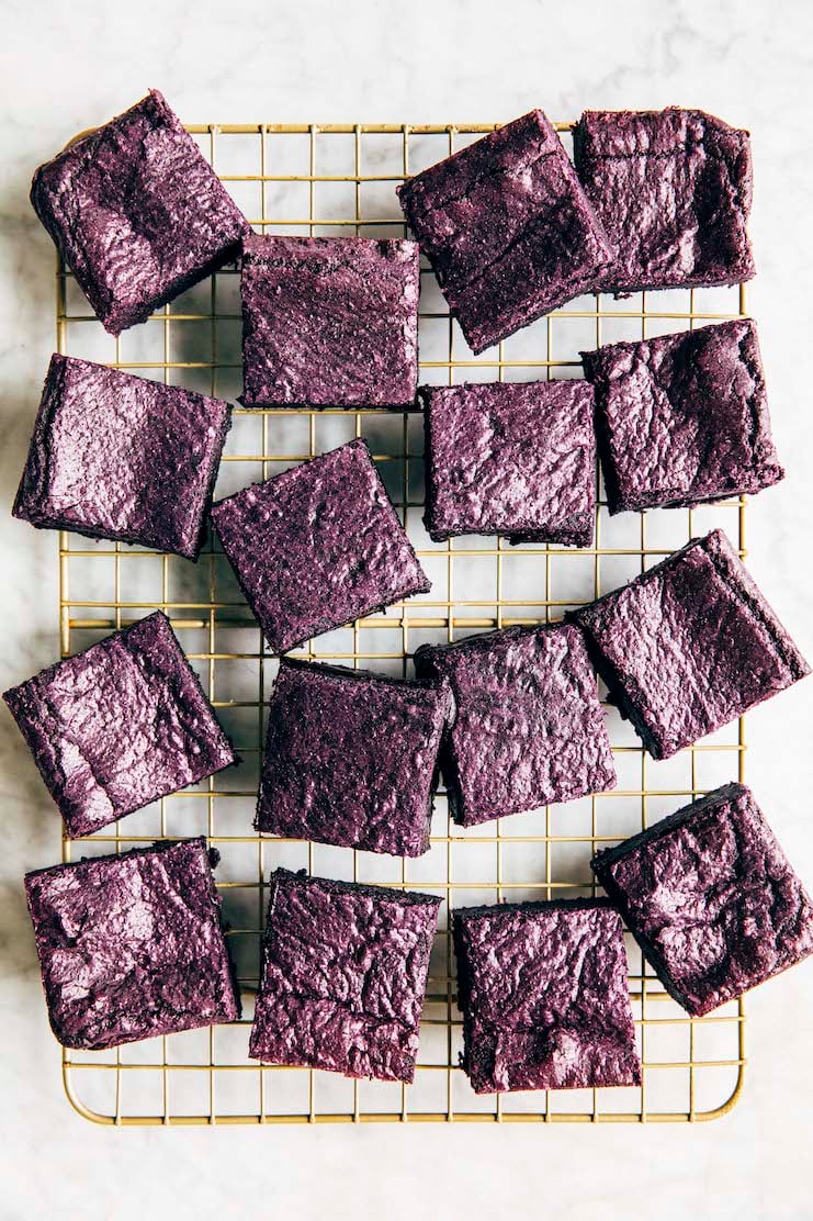 photo of ube brownies on a gold wire rack on a marble tabletop