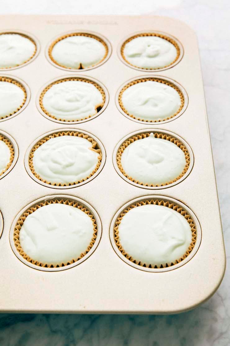 photo showing a muffin pan filled with pistachio pudding muffin batter before being baked