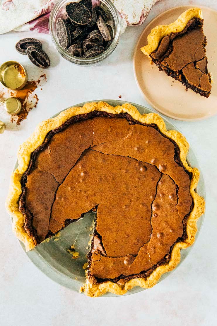 a photo of a chocolate chess pie with a slice removed