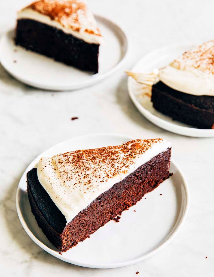 A photo of a chocolate cake with white frosting and a moist crumb. 