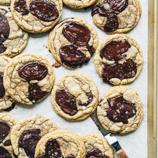A photo of chocolate chip cookies on a gold sheet pan.