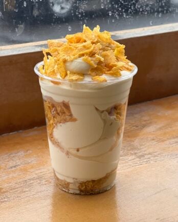 photo of sundae topped with cornflakes on wood table