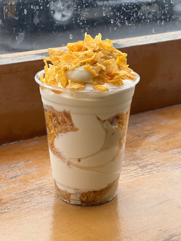 photo of sundae topped with cornflakes on wood table