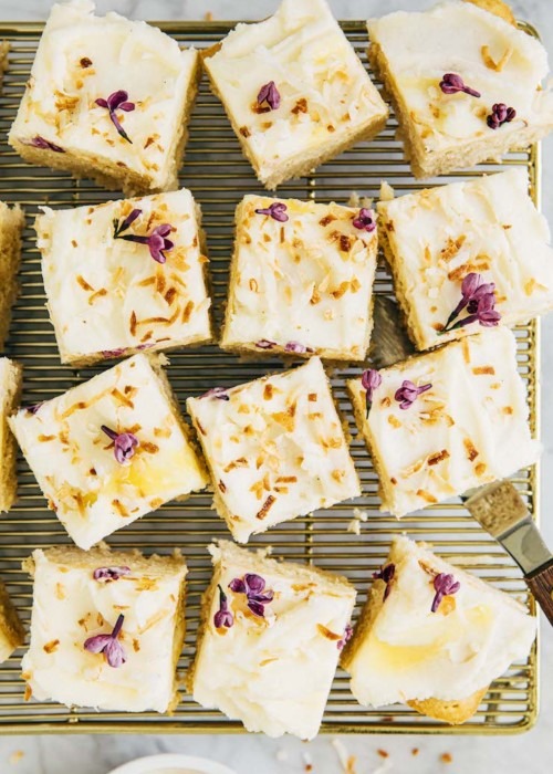 photo of coconut cake squares on gold cooling rack