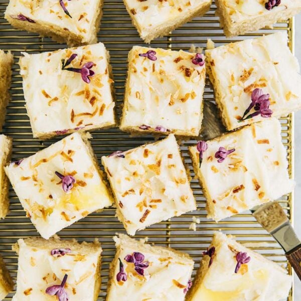 photo of coconut cake squares on gold cooling rack