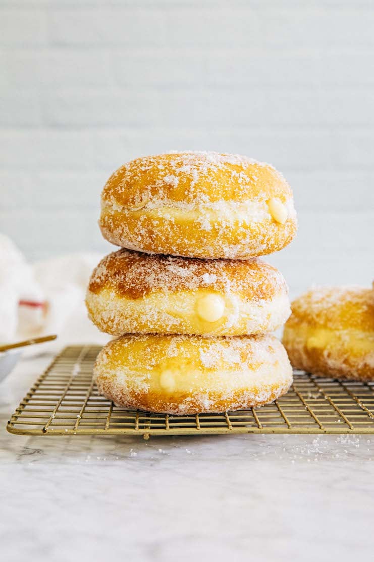 photo of stack of malasadas on gold wire rack