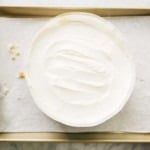 photo of milk bar birthday cake being assembled with frosting