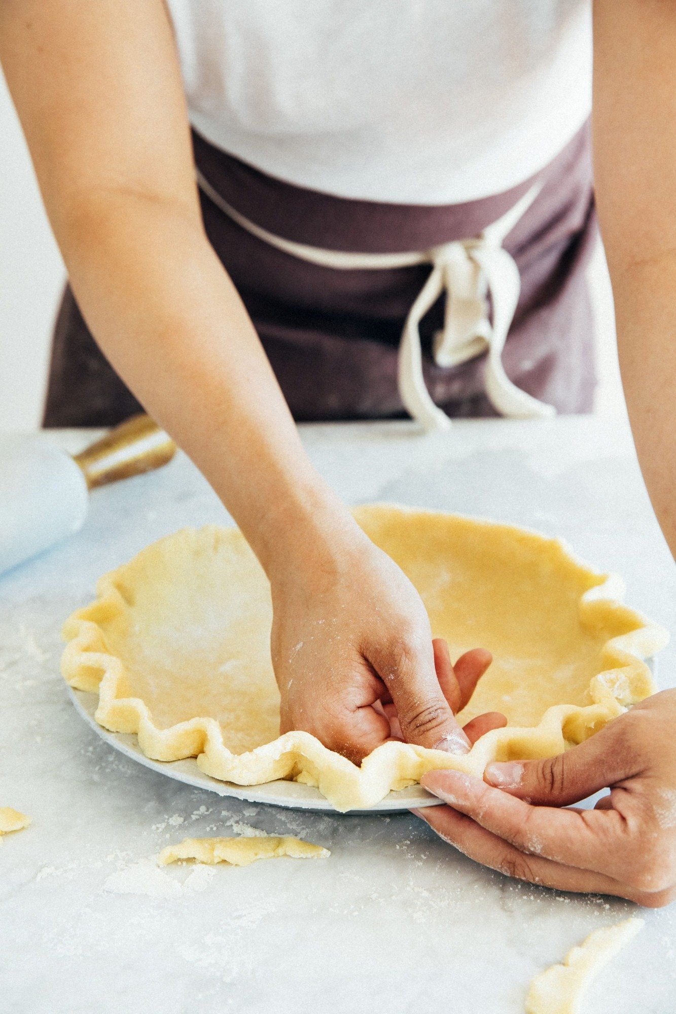 photo of a person crimping pie crust edge