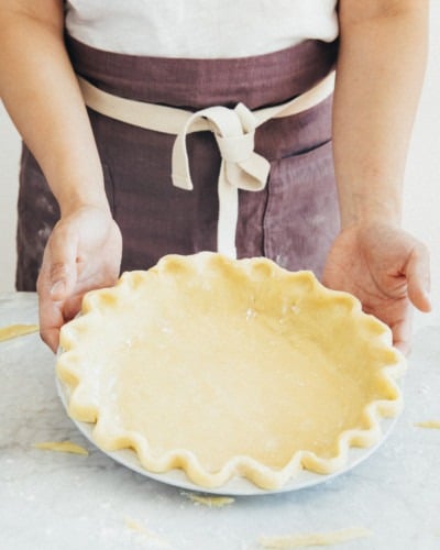 photo of a person showing off an unbaked pie crust