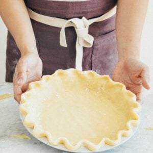 photo of a person showing off an unbaked pie crust