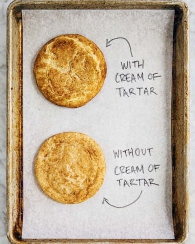 photo of two snickerdoodle cookies on a metal sheet pan