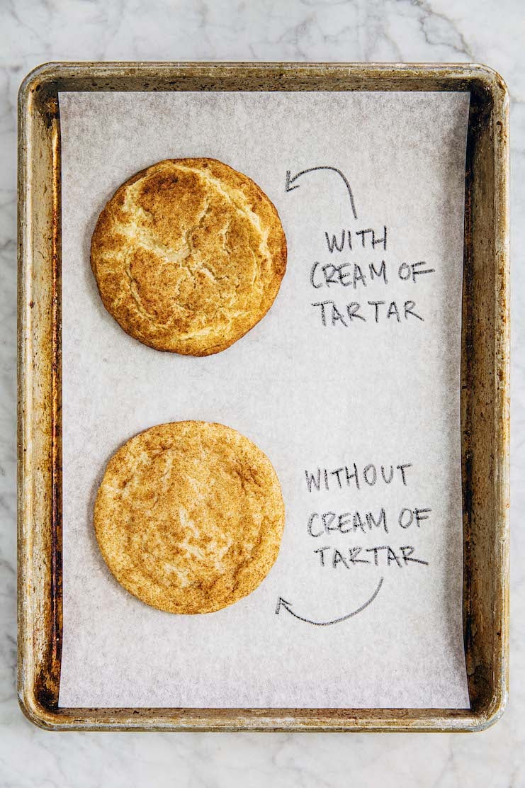 photo of two snickerdoodle cookies on a metal sheet pan