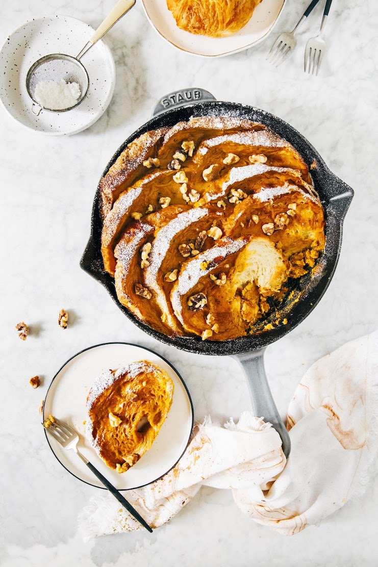 photo of pumpkin french toast casserole in cast iron pan on marble tabletop