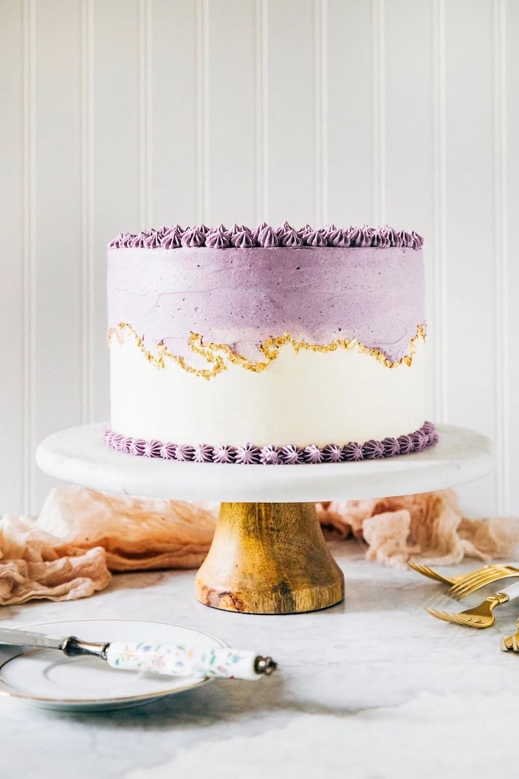 photo of ube layer cake on white cake stand
