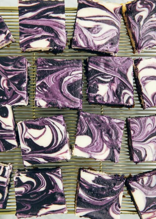photo of sliced ube cheesecake bars on gold wire rack