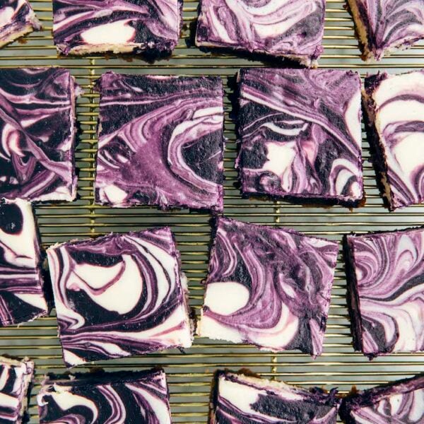 photo of sliced ube cheesecake bars on gold wire rack