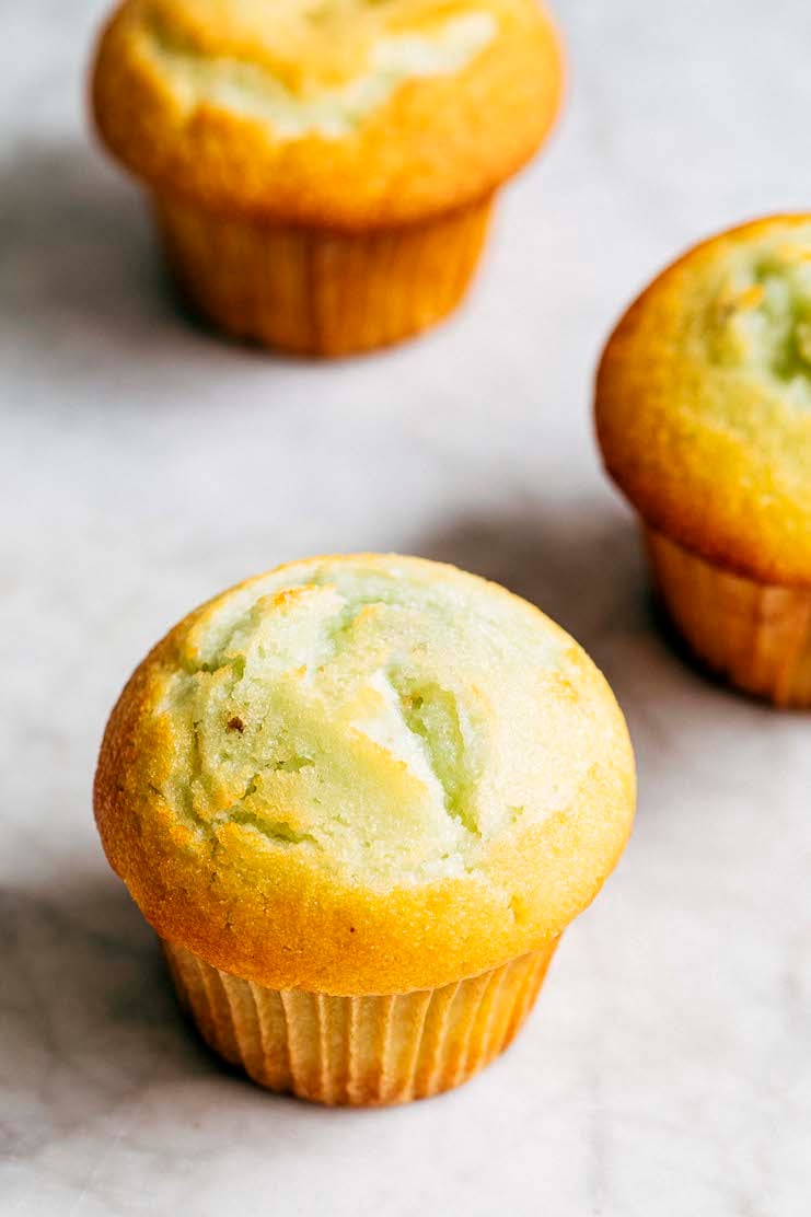 photo of three pistachio pudding muffins on a marble tabletop
