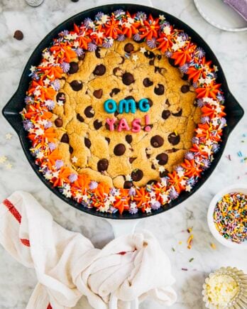 photo of my best chocolate chip cookie cake in a white cast iron pan on a marble tabletop