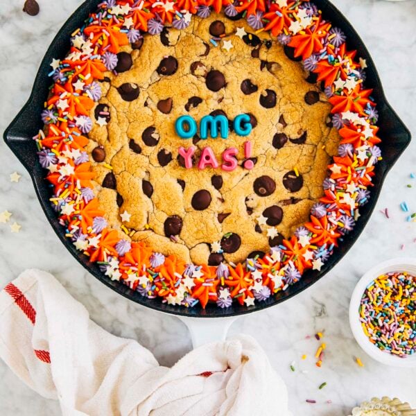 photo of my best chocolate chip cookie cake in a white cast iron pan on a marble tabletop