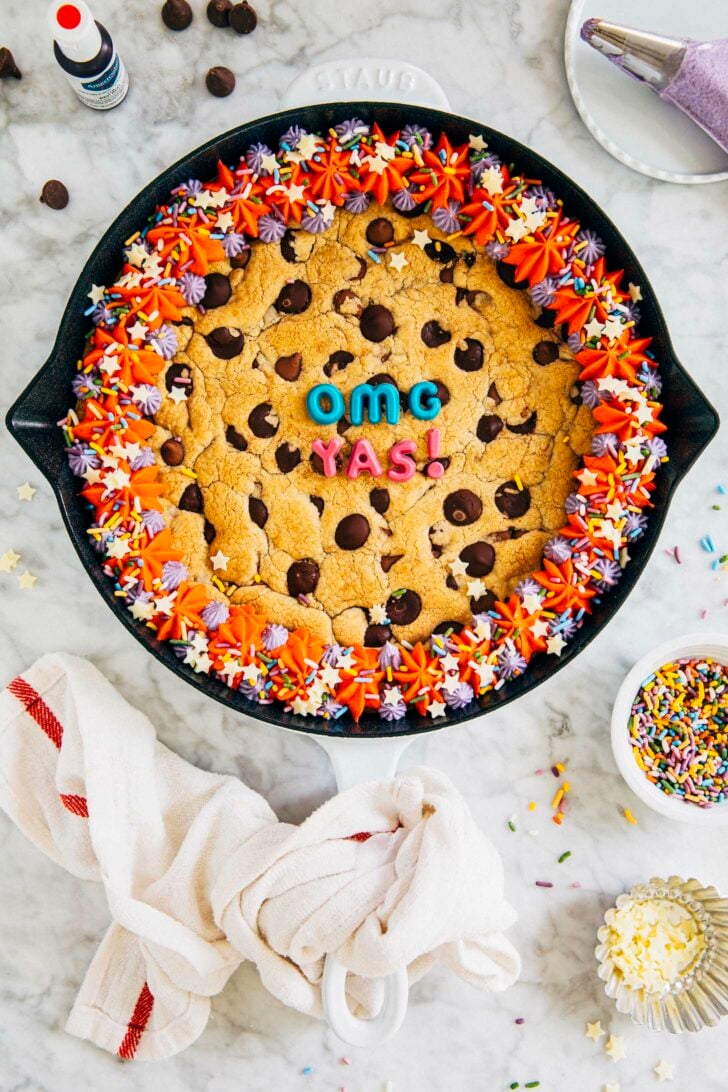 photo of my best chocolate chip cookie cake in a white cast iron pan on a marble tabletop
