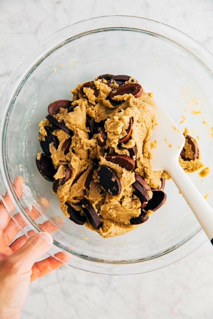 process shot showing how to make rye chocolate chip cookies showing unbaked cookie dough in glass bowl