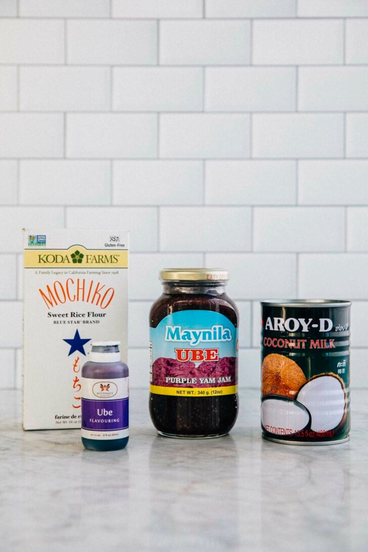 photo of the key ingredients for making ube mochi cake: mochiko flour, ube halaya jam, ube extract, canned coconut milk