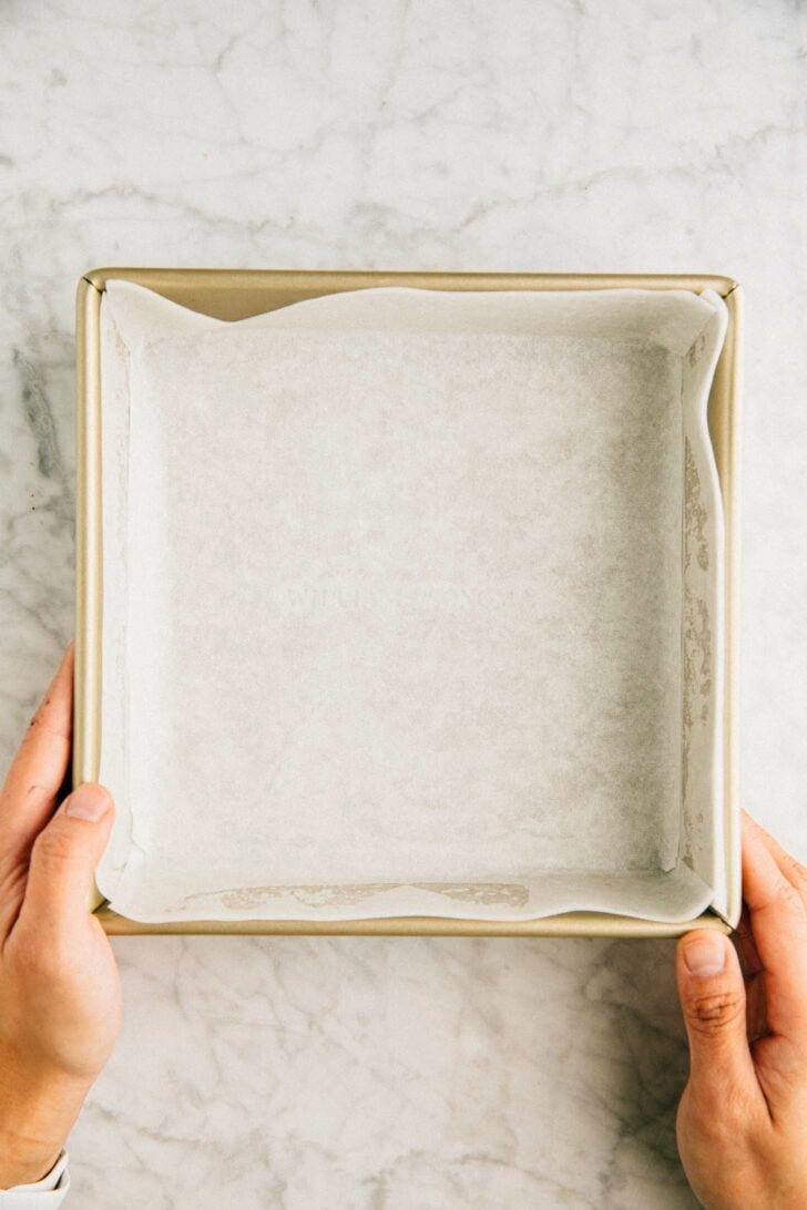 photo showing how to line the cake pan for ube mochi cake with parchment paper