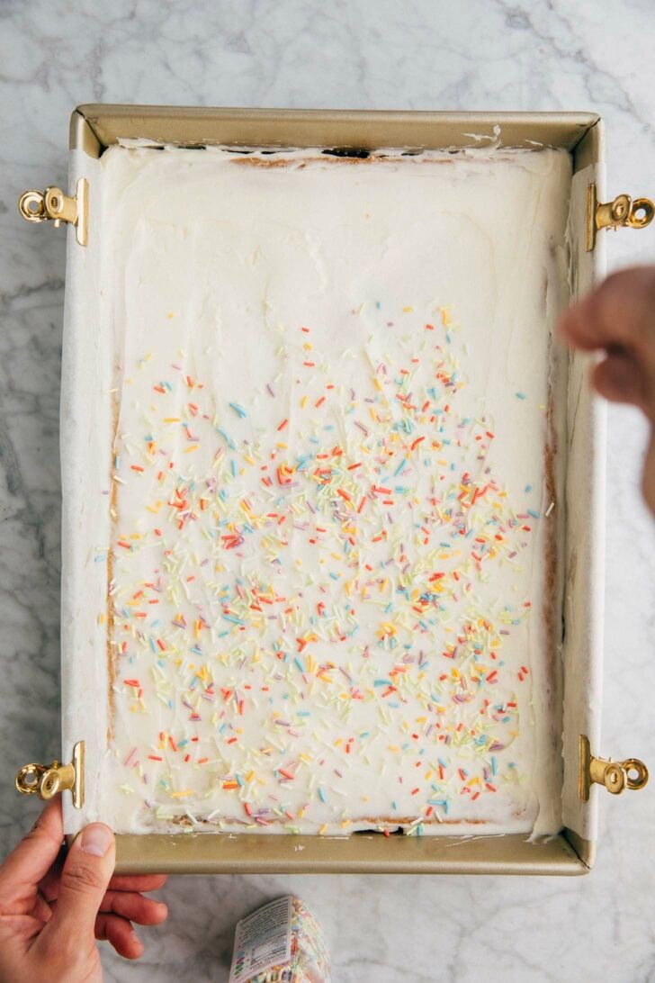 photo of michelle from hummingbird high decorating the pistachio pudding bars with sprinkles