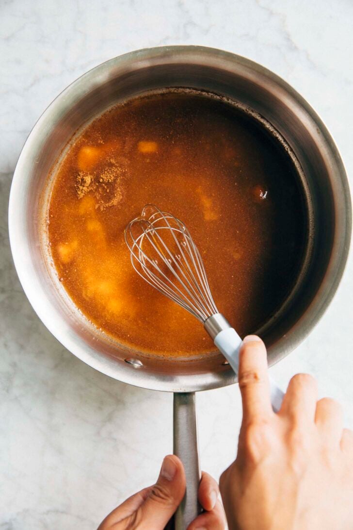 Photo of Michelle from Hummingbird High whisking the ingredients for the pumpkin puree in a stainless steel sauce pan