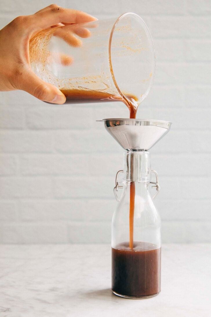 photo of Michelle from hummingbird high pouring the pumpkin spice syrup through a funnel into a glass bottle