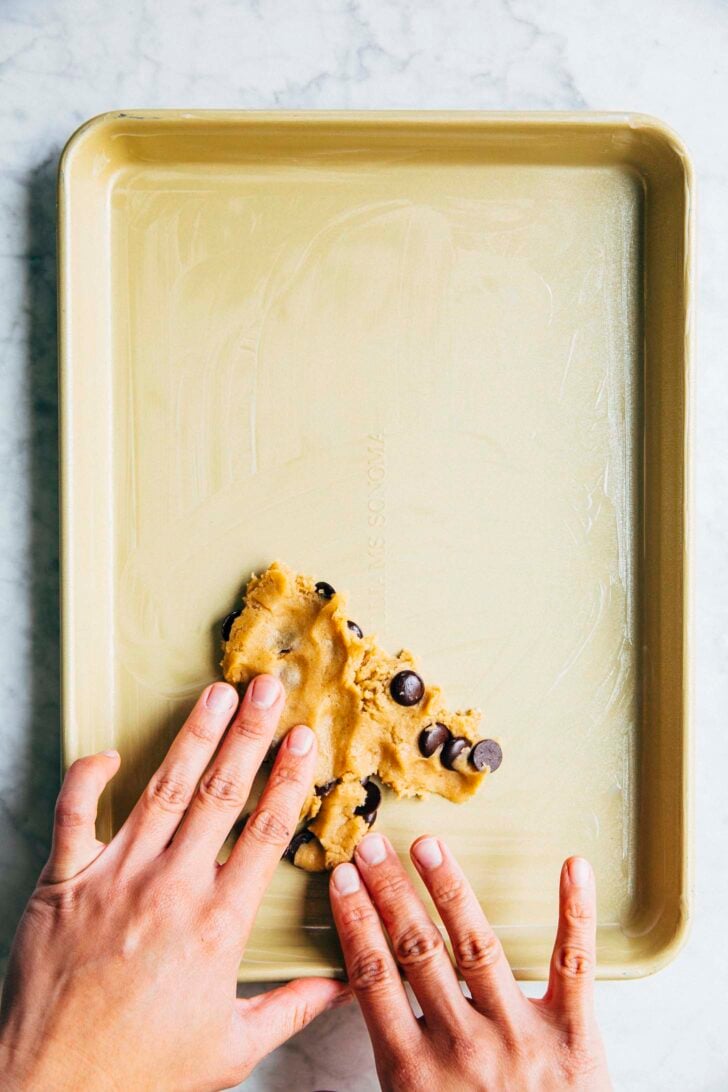 photo of michelle from hummingbird high pressing the cookie dough onto the pan with her hands