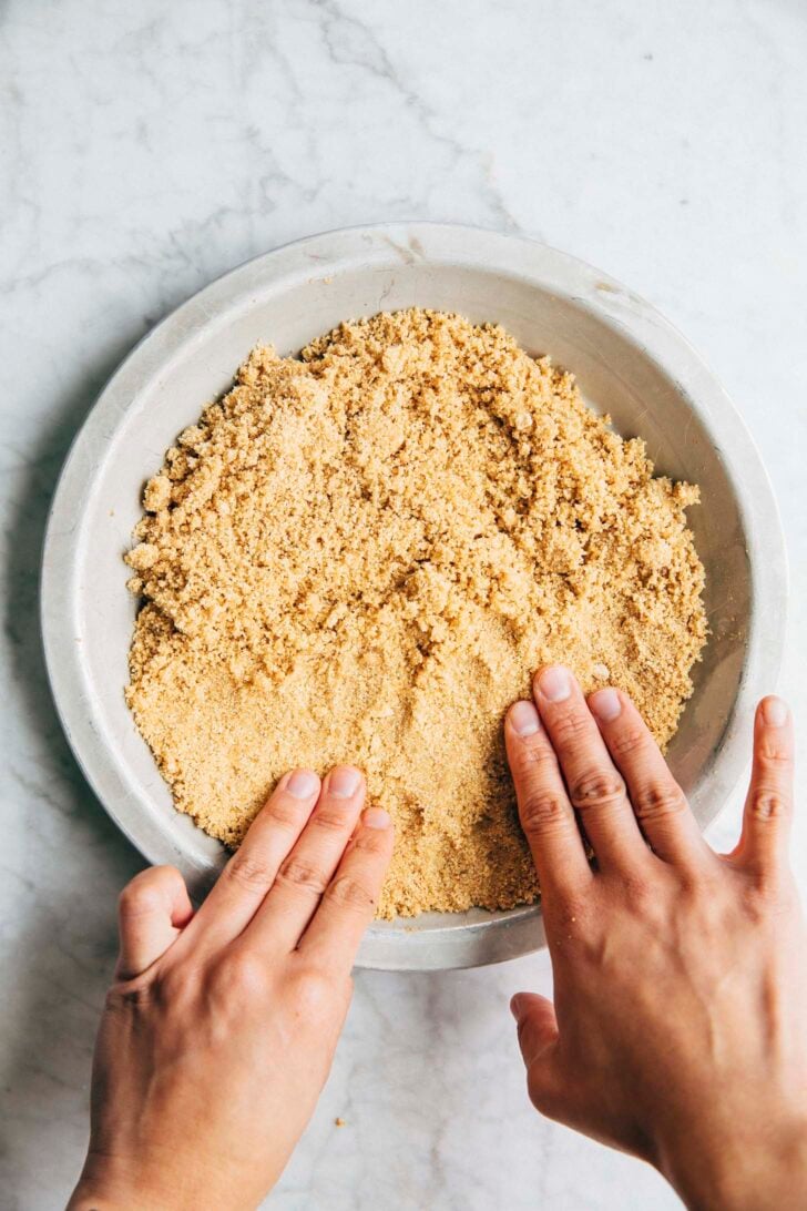 photo of Michelle from Hummingbird High pressing the crumbs into the pan to make the pie crust for Baja Blast pie