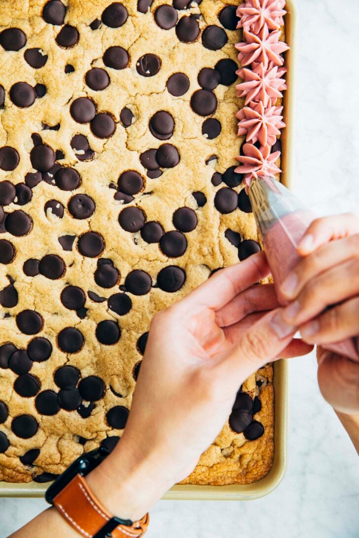 photo of michelle from hummingbird high piping frosting onto the cookie cake