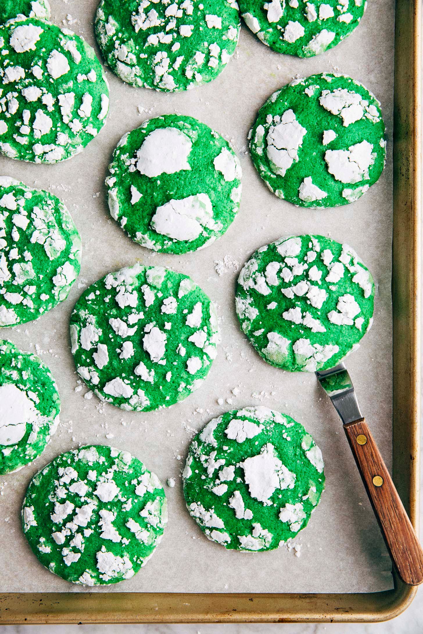 Photo of vibrant green pandan crinkle cookies on a gold sheet pan
