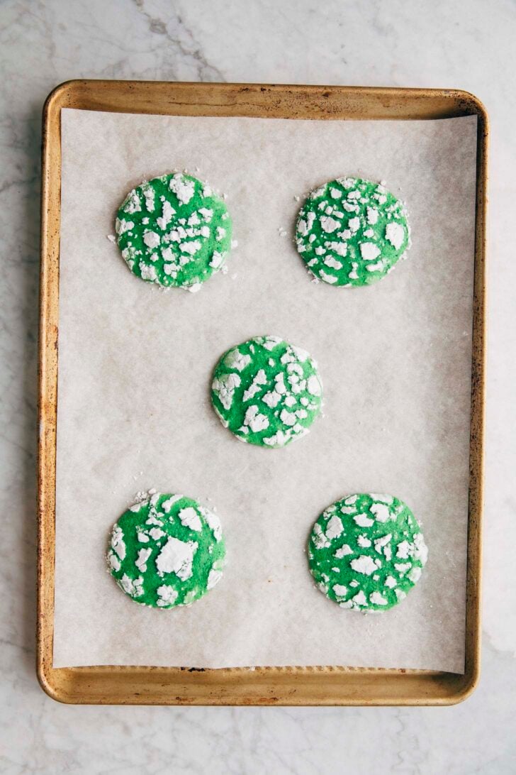 Photo of the baked pandan crinkle cookies on a gold sheet pan