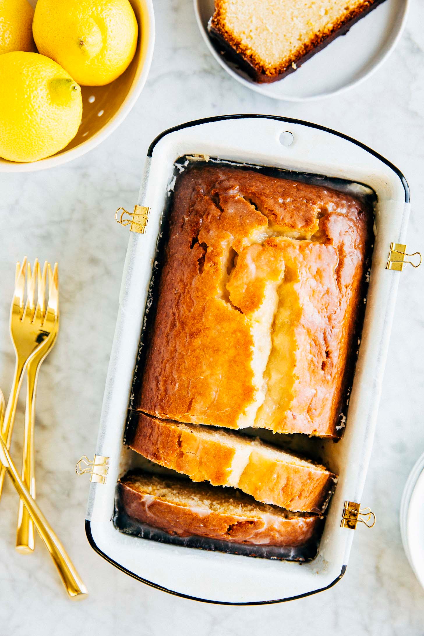 Photo of lemon yogurt loaf slices in a white loaf pan