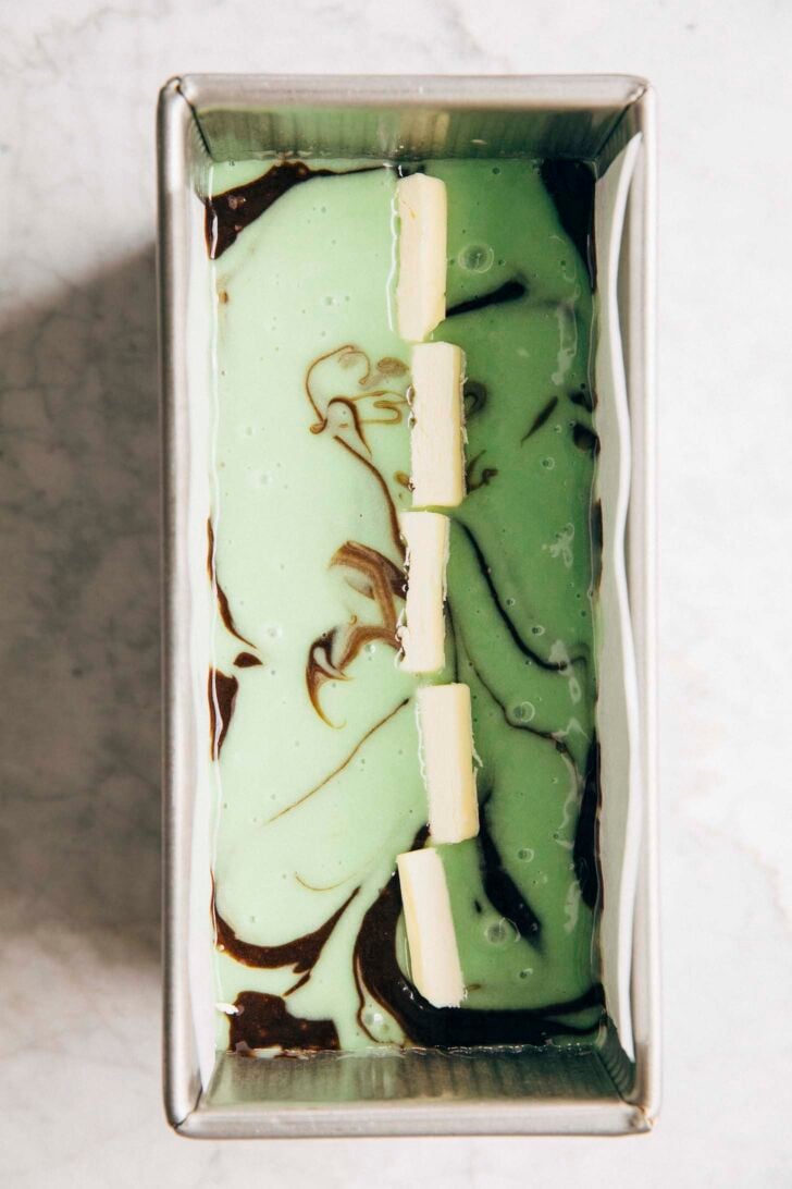 Photo showing the butter being placed on top of the loaf cake