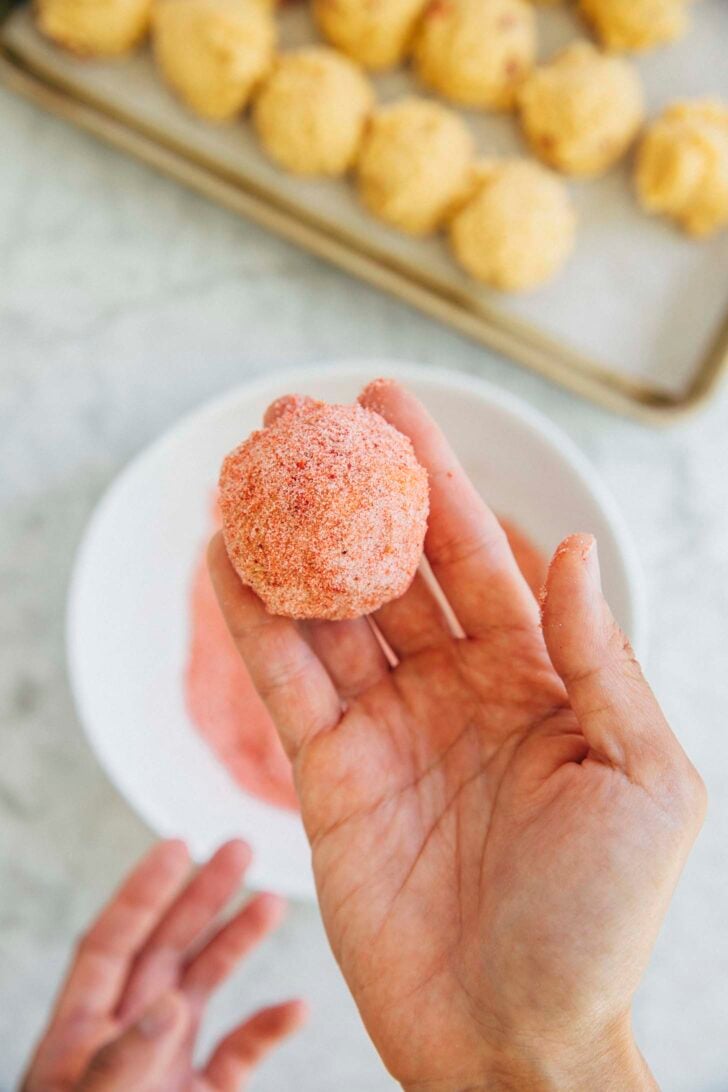 photo of michelle holding up a strawberry doodle cookie dough ball ready for baking